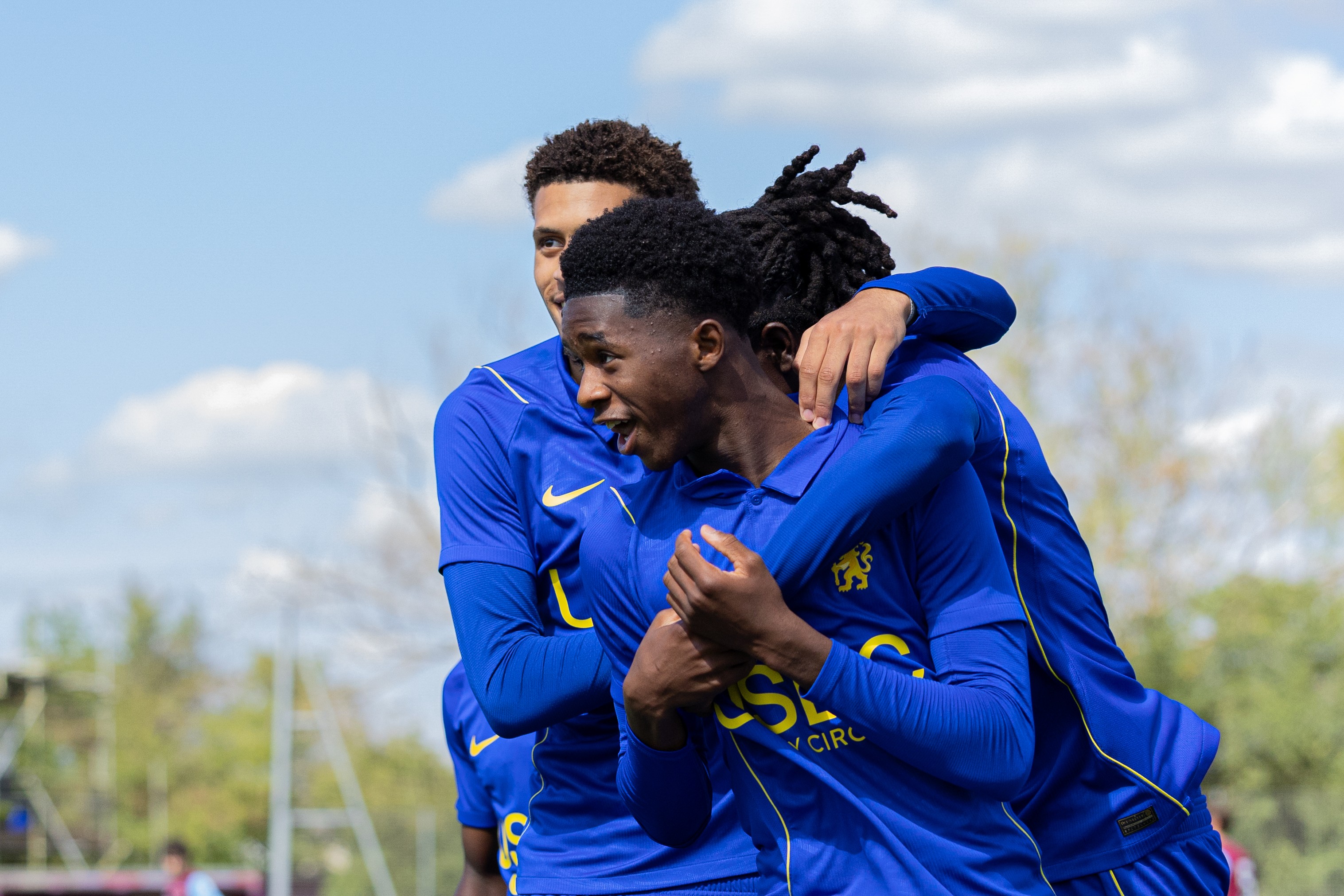 Chelsea academy players hugging in celebration