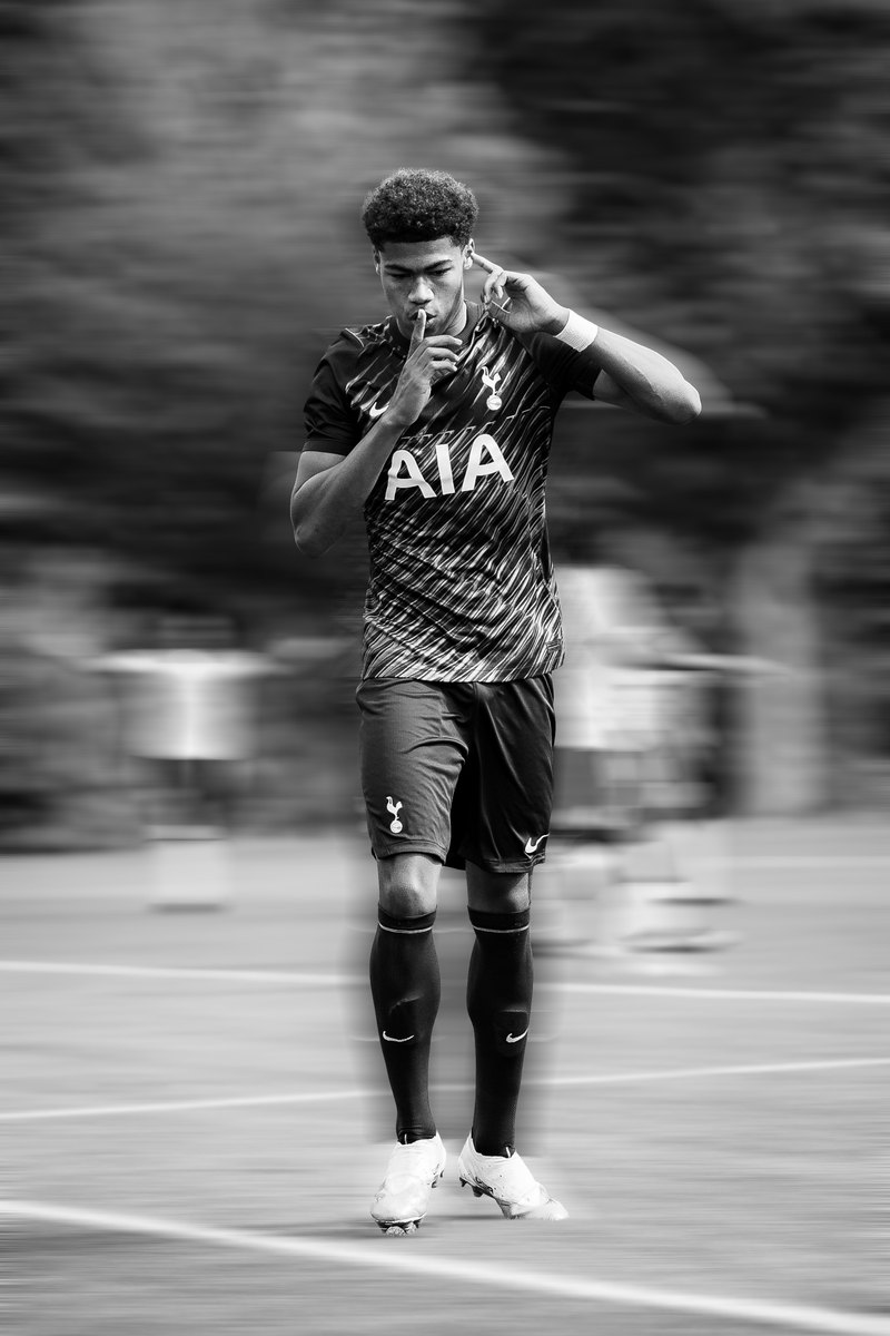 Tottenham player in the away kit with a finger to his lips, black and white, motion blur edit