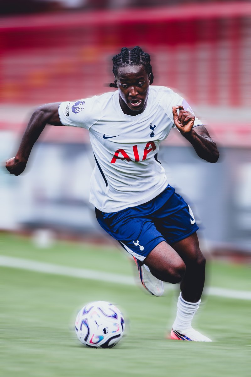 Tottenham player sprinting onto the ball in front of red stands, motion blur edit