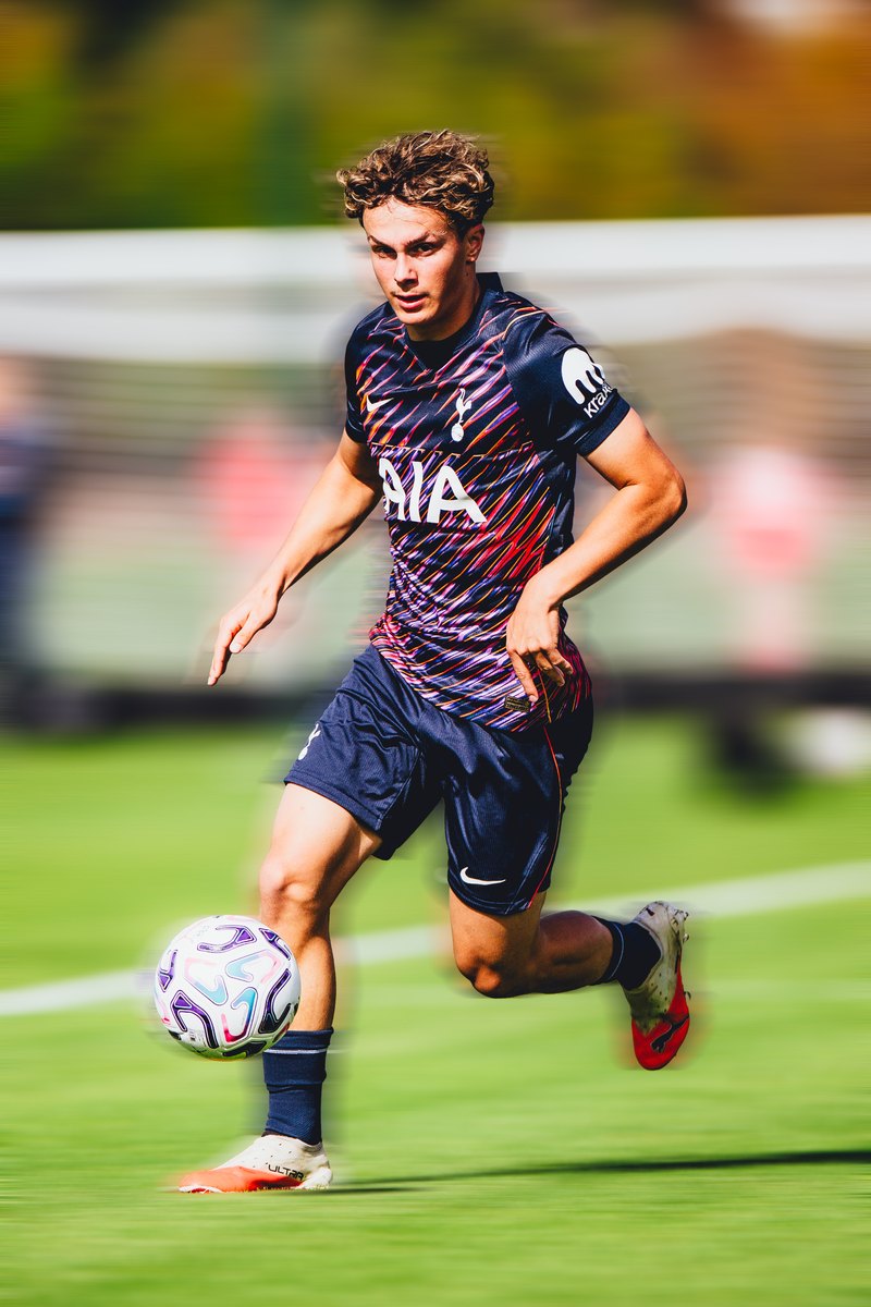 Tottenham player in the away kit driving forward with the ball, motion blur edit