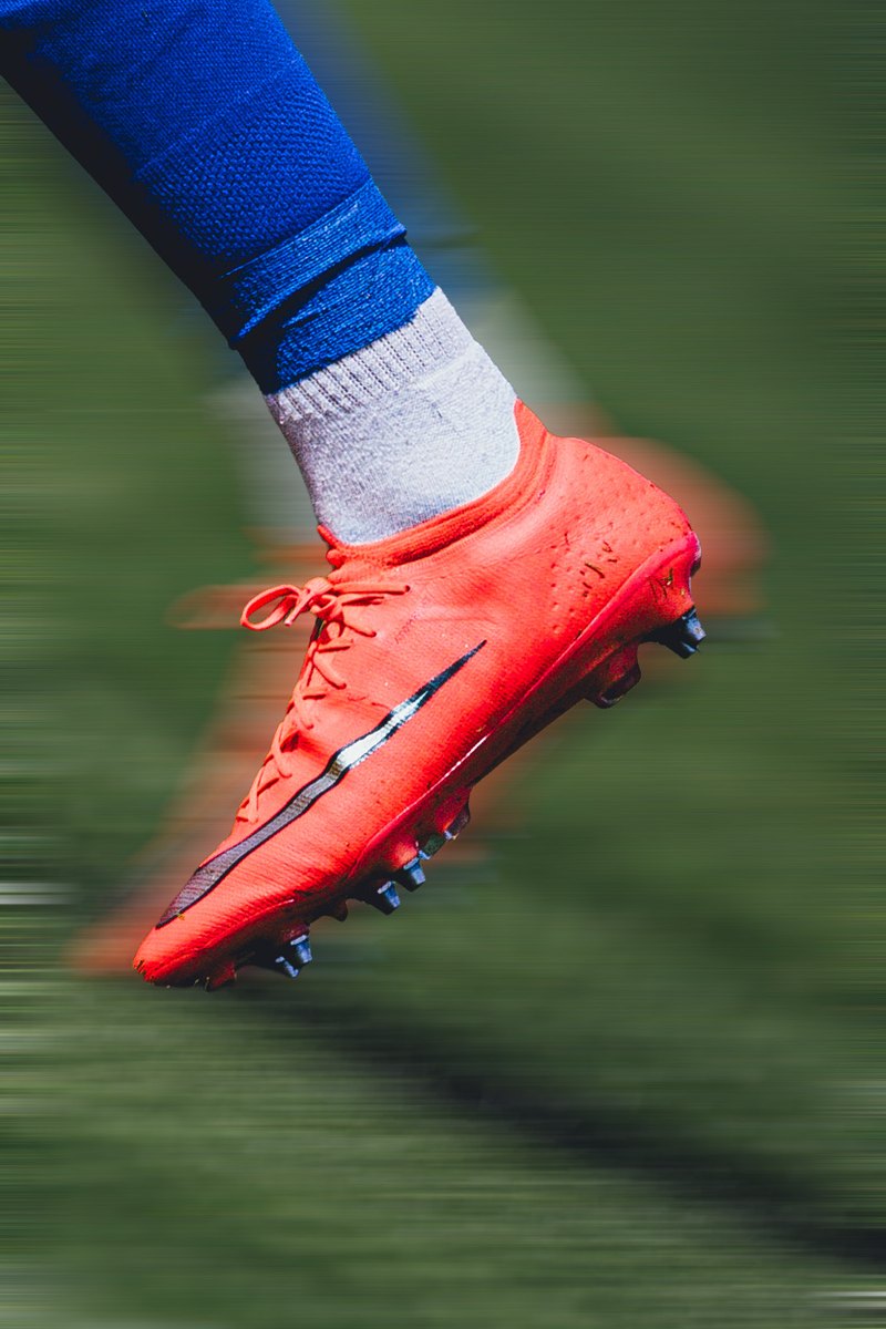Close-up of an orange football boot, motion blur edit