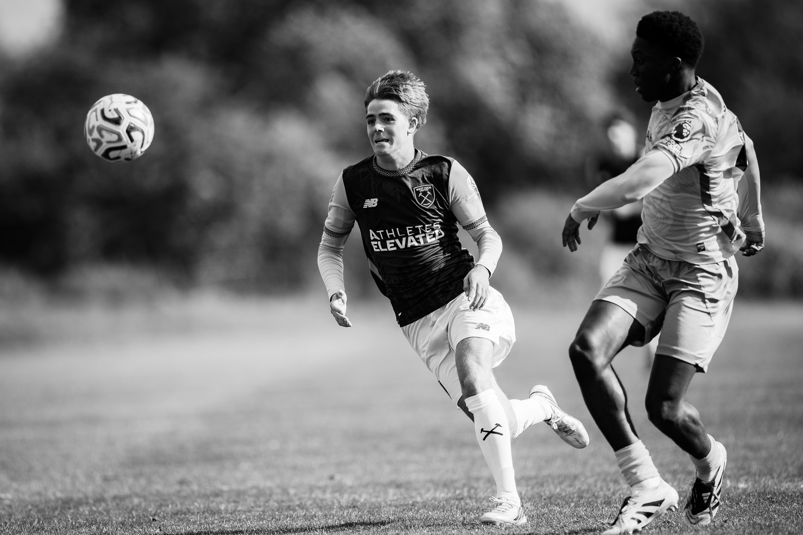 West Ham and Norwich players chasing a high ball, black and white