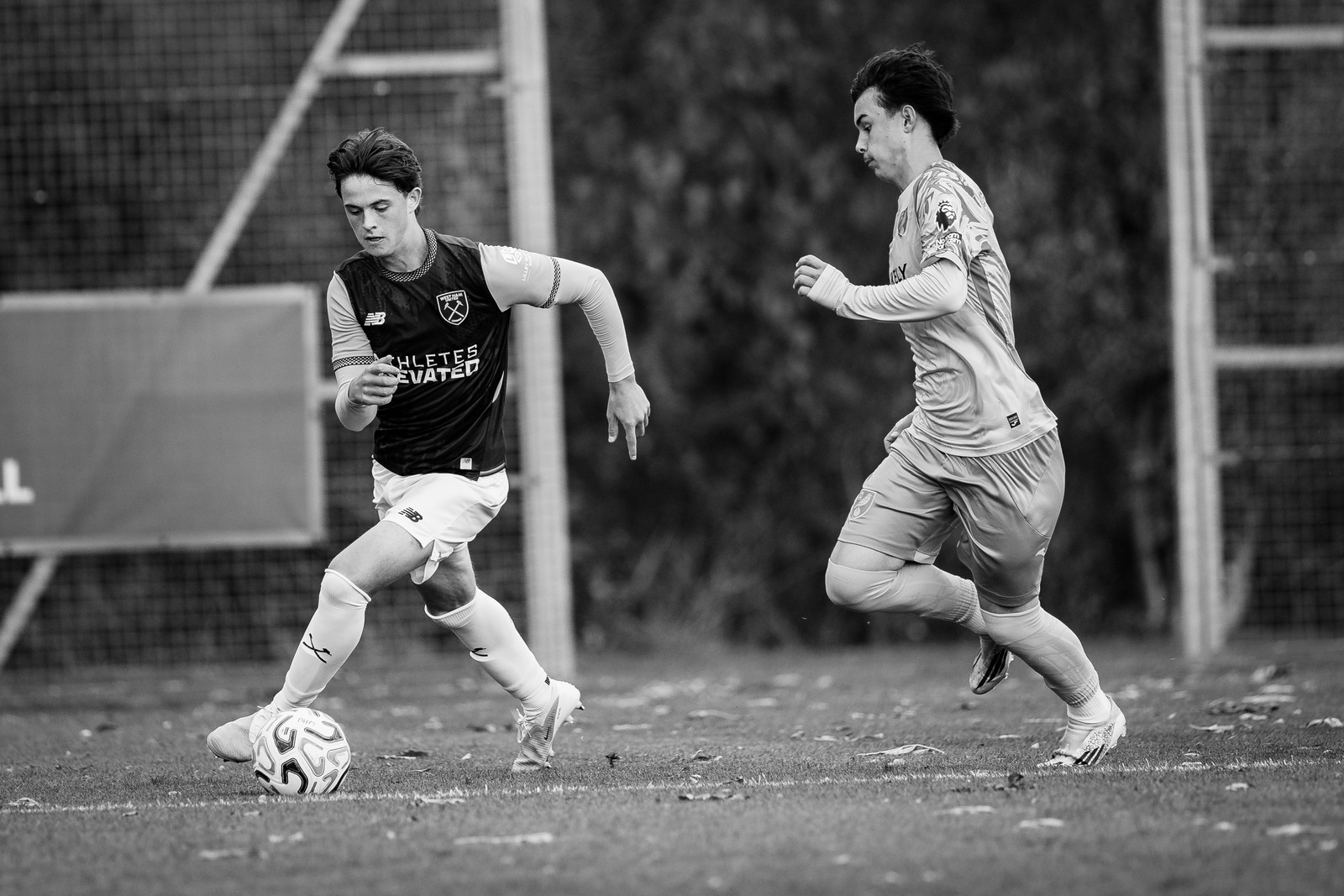 West Ham and Norwich players running for the ball, black and white
